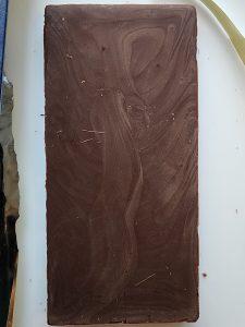 A bar of bloomed chocolate, it looks like grey woodgrain.
