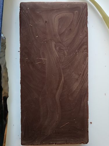 A bar of bloomed chocolate, it looks like grey woodgrain.